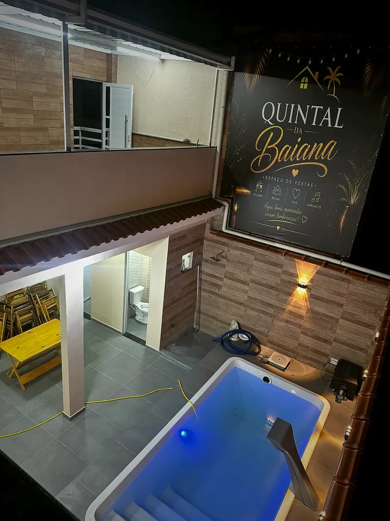 Vista geral do Quintal à noite: banheiros, área coberta e piscina